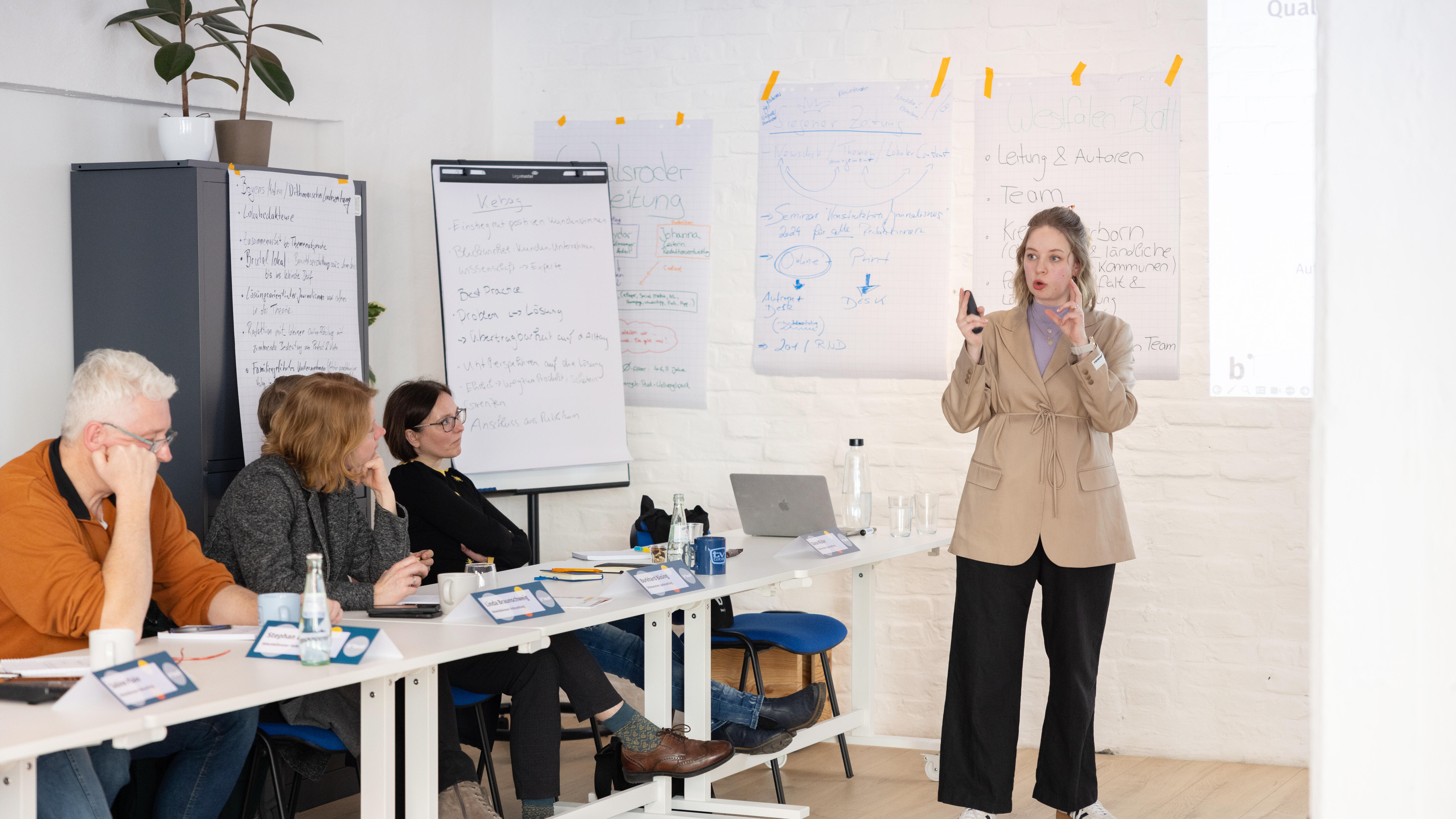 Lisa Urlbauer explains concepts to workshop participants sitting in chairs