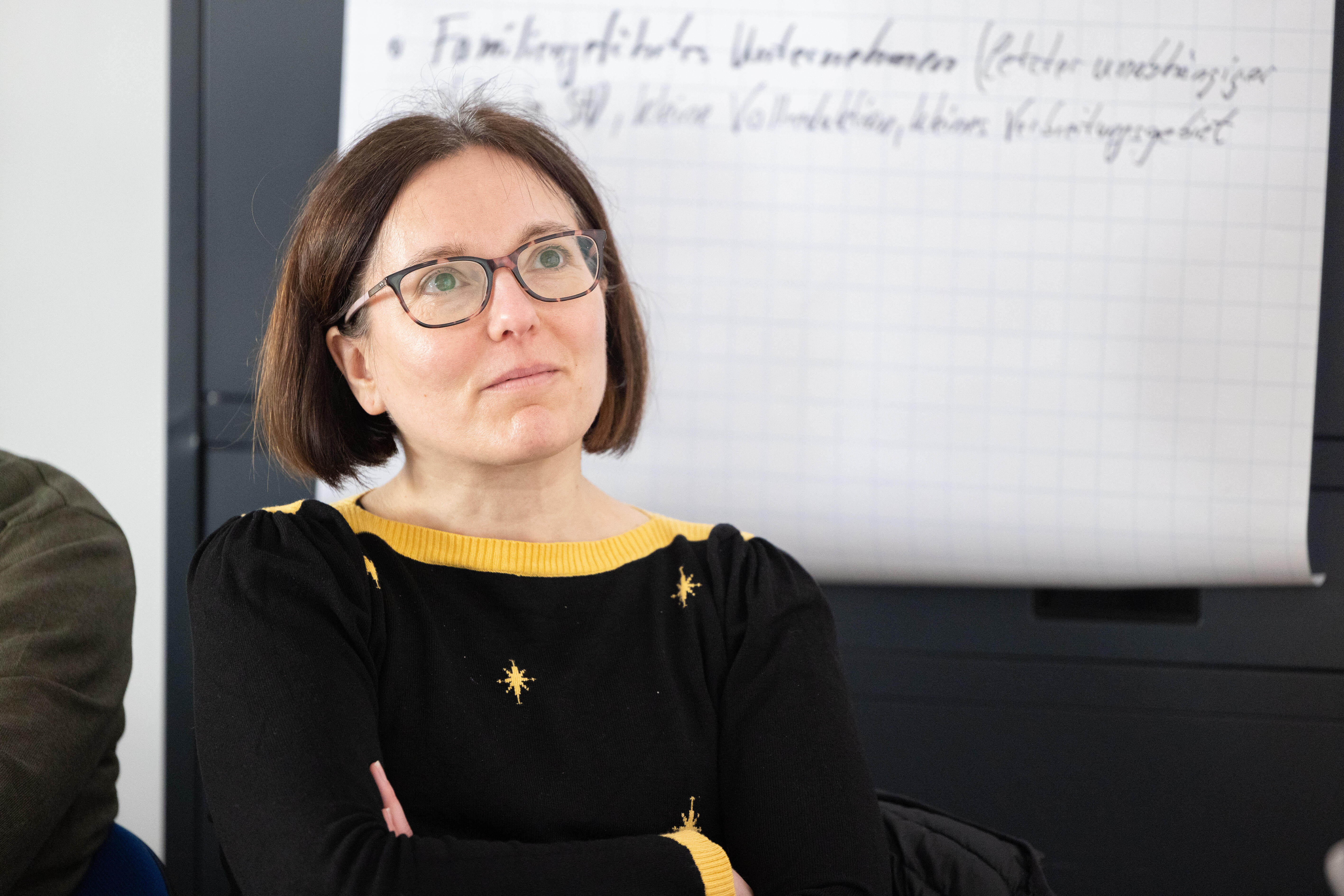 A woman looks attentively at something out of sight during a workshop